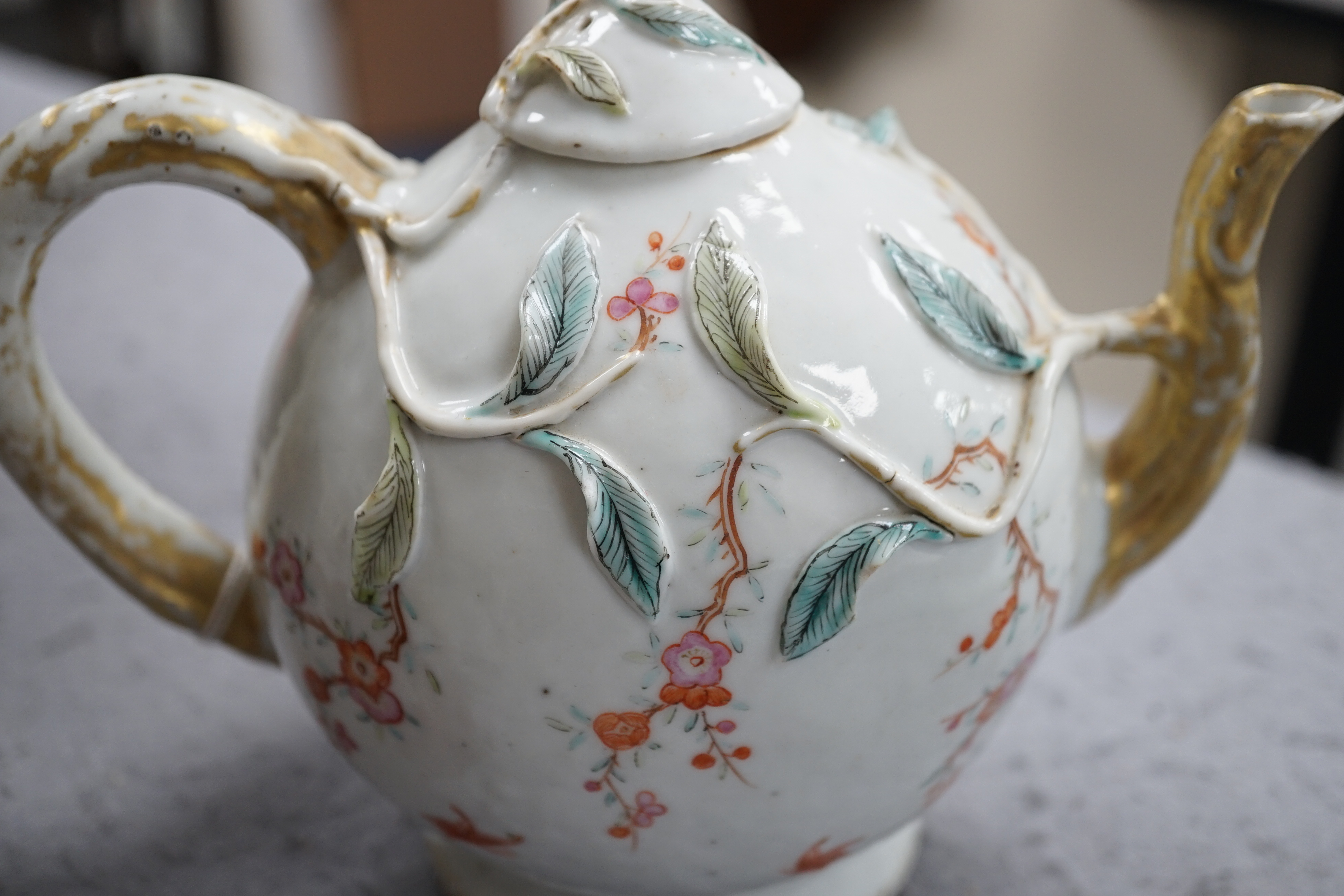 A Chinese enamelled porcelain peach-shaped teapot, Qianlong period (1736-95), wear to gilding